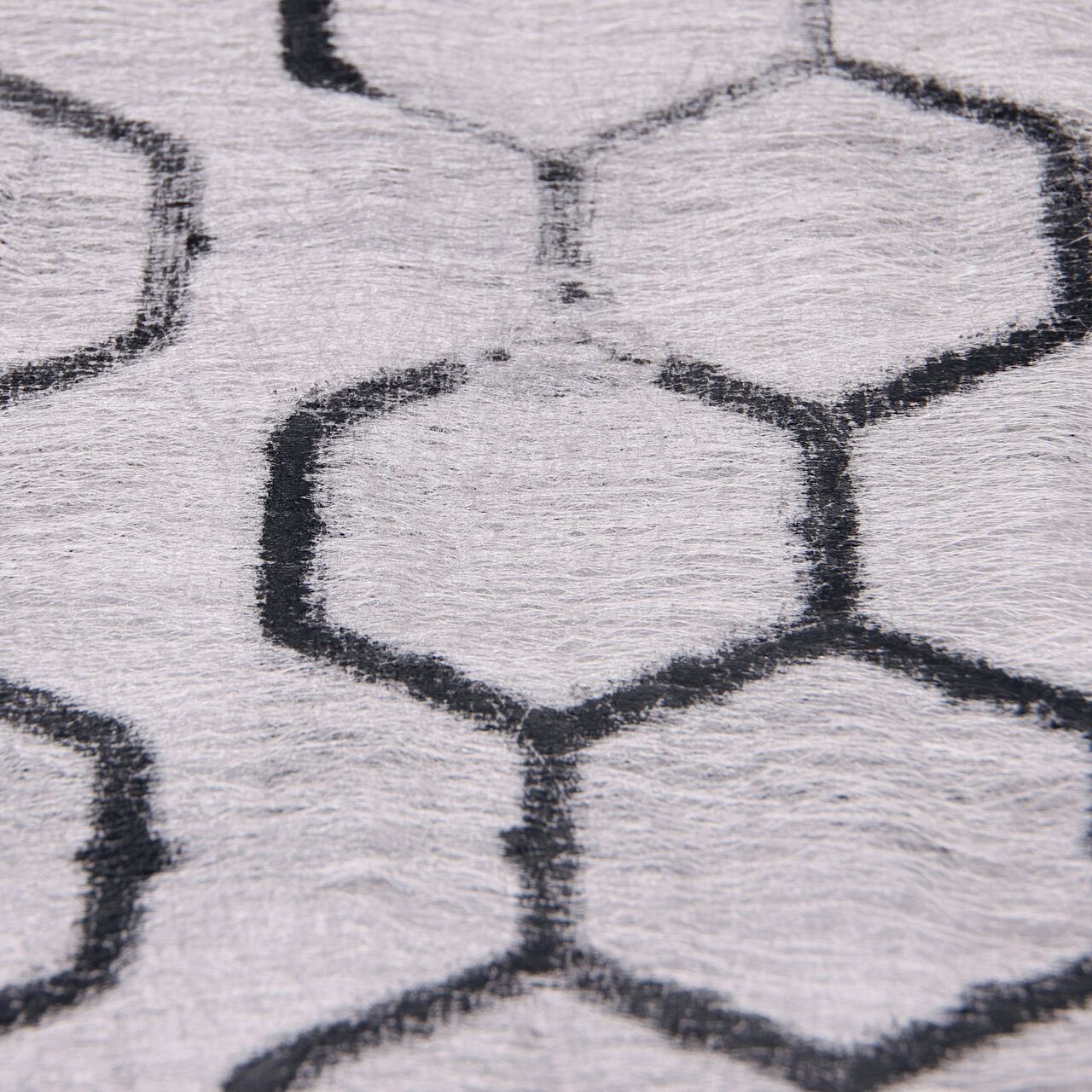 Closeup View of thermally welded, puncture-resistant geotextile fabric on the Black NDS EZ Roll® Gravel Pavers; fabric prevents gravel from migrating downward and lifting the paver, and is also porous to allow for filtration of stormwater runoff