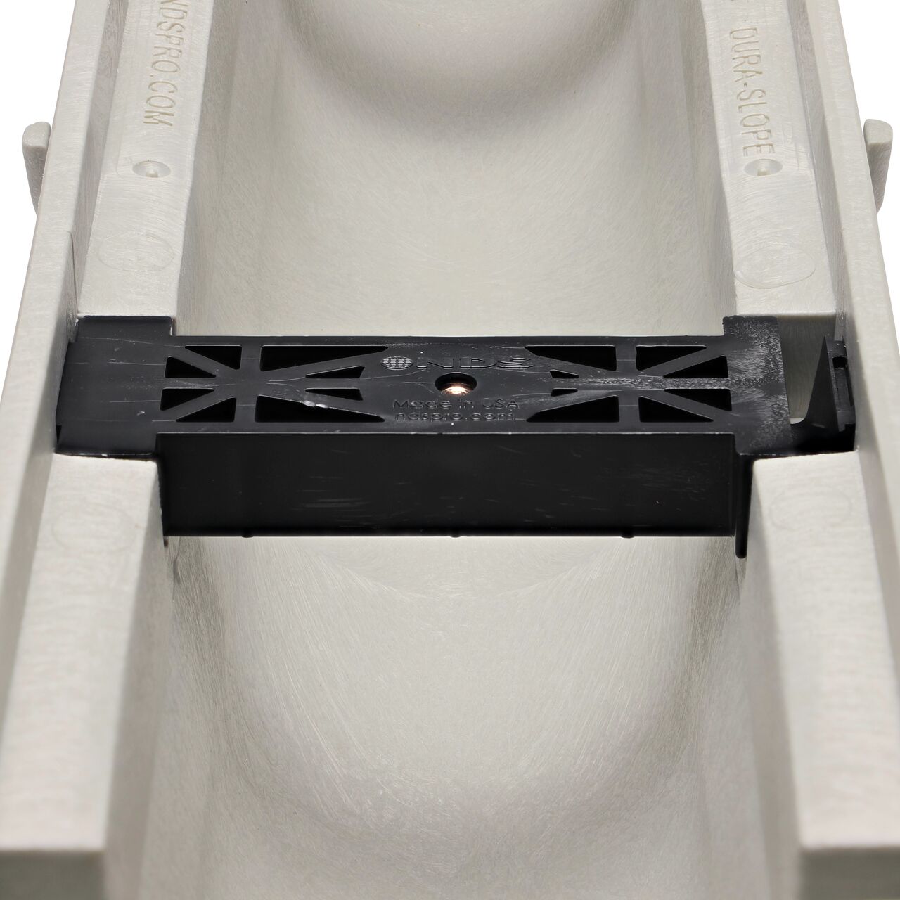Closeup view of the grate locking system on the NDS Dura Slope 4.34 Deep Neutral Channel Drain, which locks grate to the integral frame (NDS DS-091N, NDS DS-092, NDS DS-093, NDS DS-094)