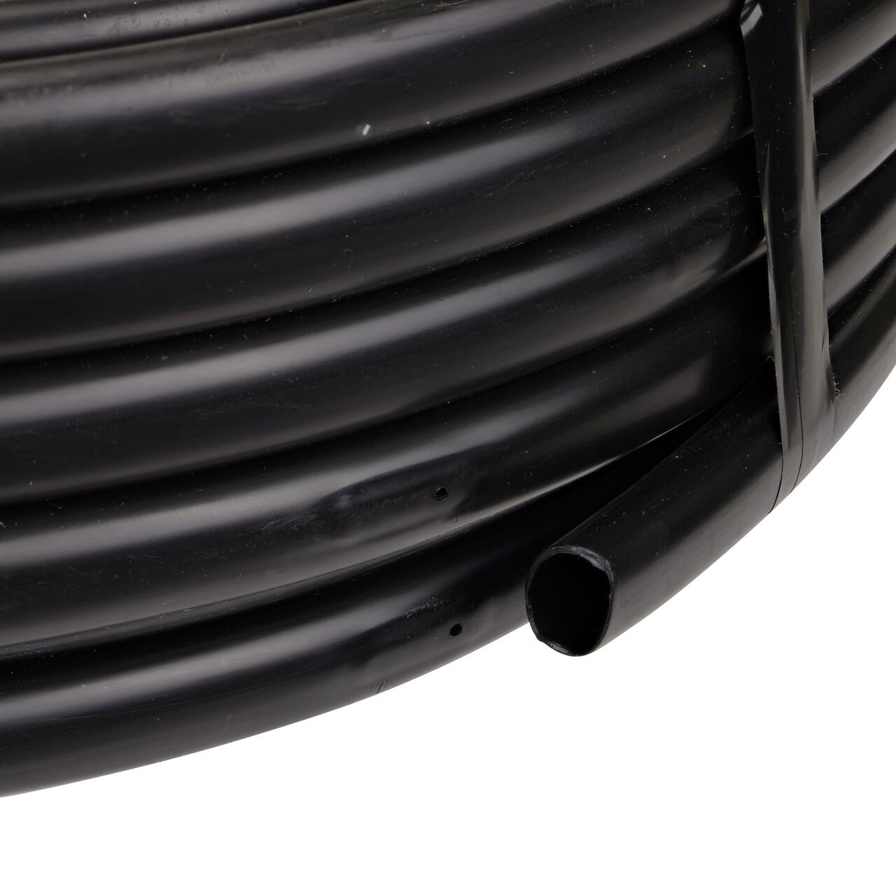 Closeup of the end of the NDS 100 ft. Black Tubing with 0.5 GPH Pressure Compensating Emitters iwth 12 in. Spacing to show how to pull out the dripline (NDS SFPC-BL-7212-01, NDS SFPC-BL-7412-01)