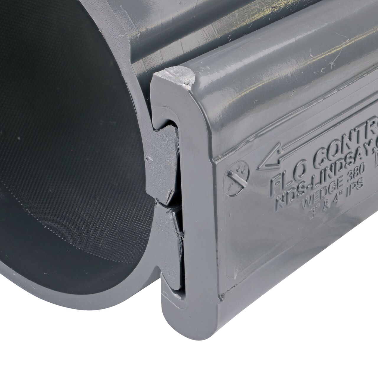 Closeup of the wedge installed securely on the NDS Clamp-It™ Rigid PVC Saddle with 1-1/4 in. FPT connection on top (NDS 444012) for 4 in. PVC pipe