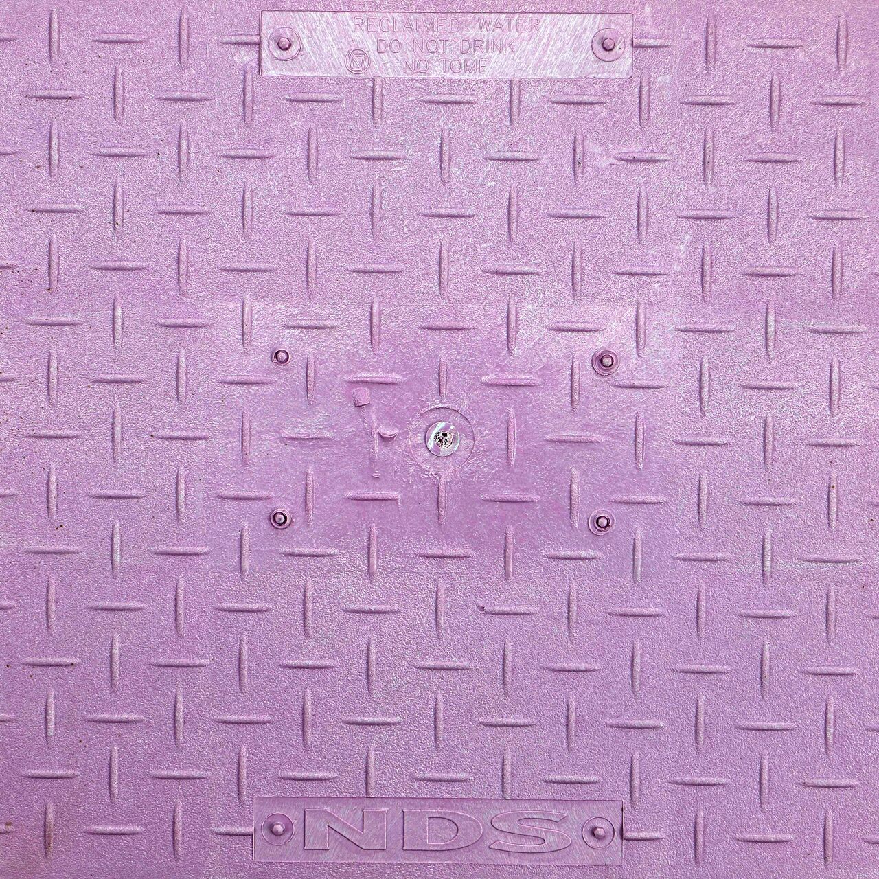 Closeup view of the Reclaimed Water markings on the Purple Reclaimed Water Drop-in cover for the NDS 13 in. X 20 in. Rectangular Standard Series Meter Cover (NDS D1500-DISPL)