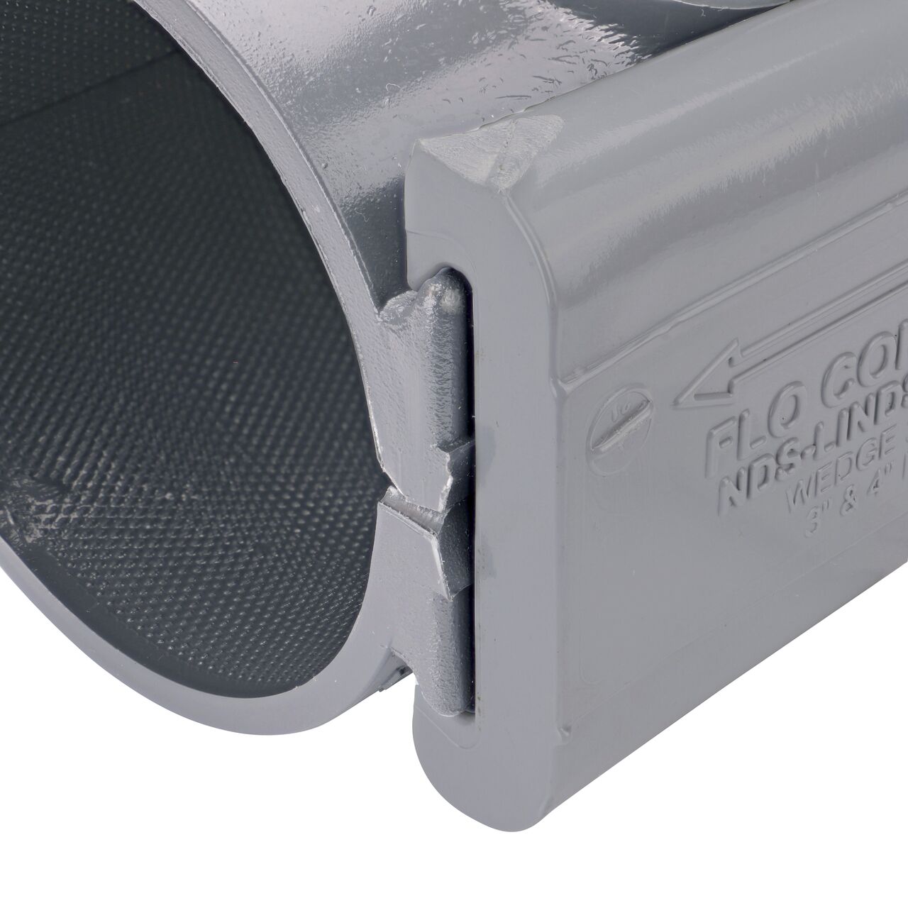 Closeup of the wedge installed securely on the NDS Clamp-It™ Rigid PVC Saddle with 1-1/4 in. FPT connection on top (NDS 443012) for 3 in. PVC pipe