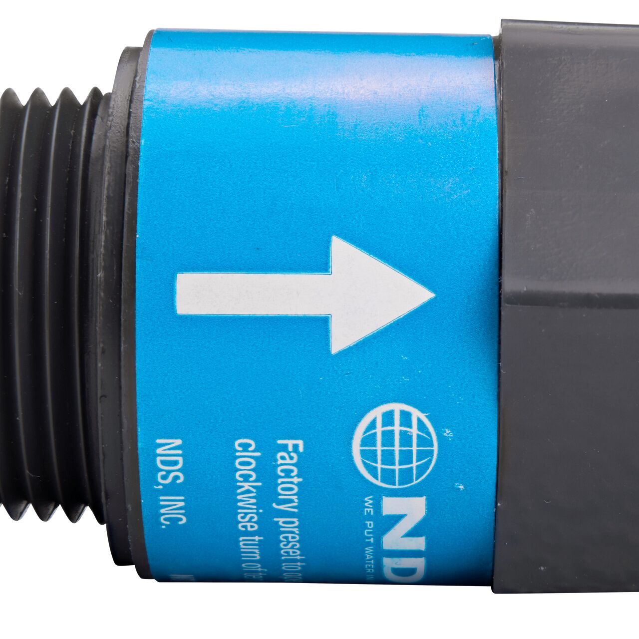 Closeup of the label marking the flow of water of the NDS Gray 1 in. IPS MPT X FPT PVC Adjustable Inline Spring Check Valve (NDS CV-1000-MF)