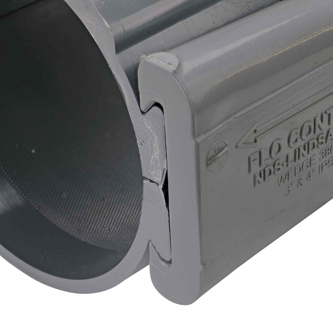 Closeup of the wedge installed securely on the NDS Clamp-It™ Rigid PVC Saddle with 2 in. FPT connection on top (NDS 444020) for 4 in. PVC pipe