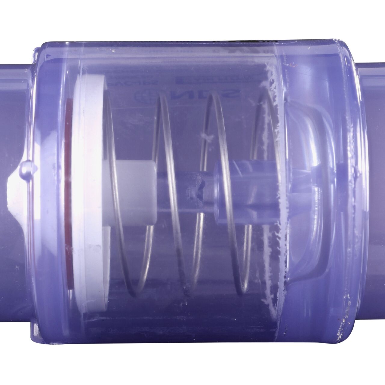 Closeup of the spring of the the 1/4 lb spring closes the flapper to prevent water from flowing the wrong direction in the NDS Clear 1-1/2 in. slip end by 2 in. spigot end PVC Air Check Valve (NDS 1050C20)