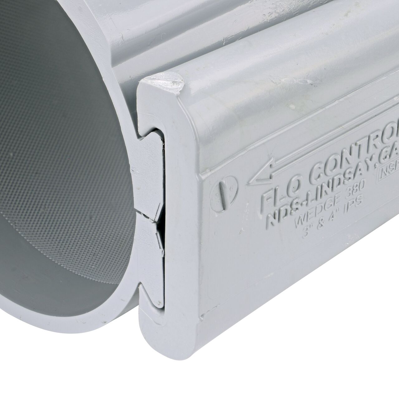 Closeup of the wedge installed securely on the NDS Clamp-It™ Rigid PVC Saddle with 1-1/2 in. FPT connection on top (NDS 444015) for 4 in. PVC pipe