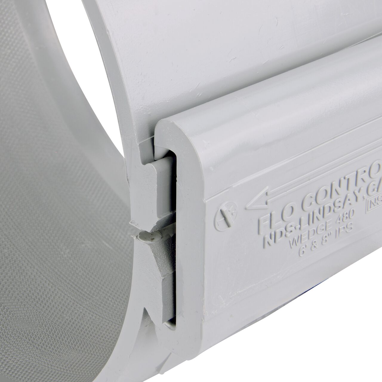 Closeup of the wedge installed securely on the NDS Clamp-It™ Rigid PVC Saddle with 2 in. slip connection on top (NDS 458020) for 8 in. PVC pipe