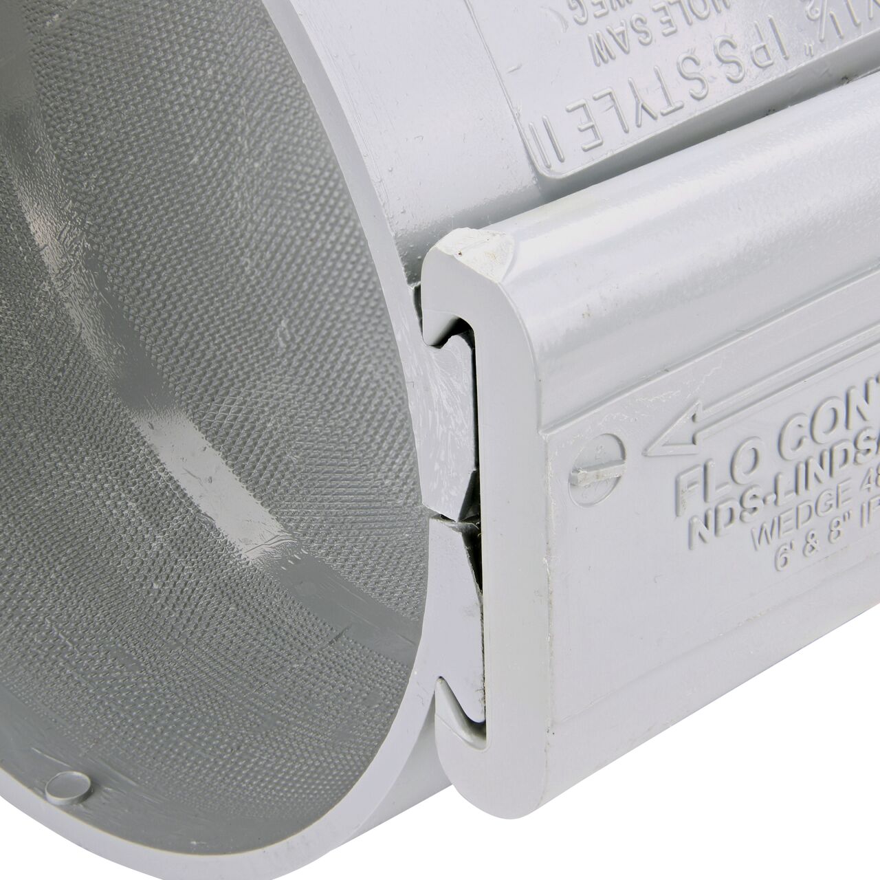 Closeup of the wedge installed securely on the NDS Clamp-It™ Rigid PVC Saddle with 2 in. slip connection on top (NDS 456020) for 6 in. PVC pipe