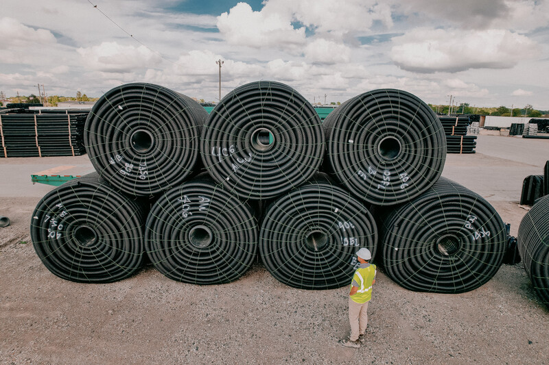 ADS Employee with Coils of Pipe